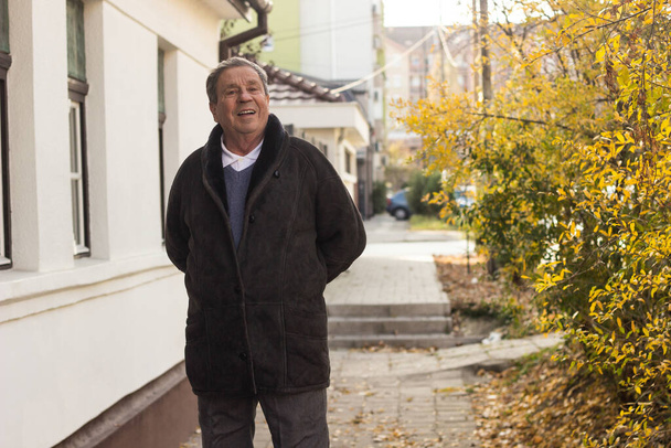 Veselý starší muž před domem - Fotografie, Obrázek