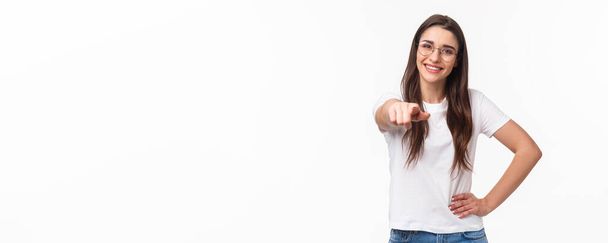 Vita-up ritratto di felice sorridente giovane donna che vi invita a far parte del suo team, reclutare persona, puntando il dito contro la fotocamera sorridente e in piedi fiducioso nella sua scelta, sfondo bianco. - Foto, immagini
