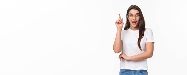 Waist-up portrait of excited, creative and smart talented pretty woman in glasses suggesting great idea, raise finger up eureka gesture, smiling enthusiastic, propose plan, think-up solution. - Фото, изображение