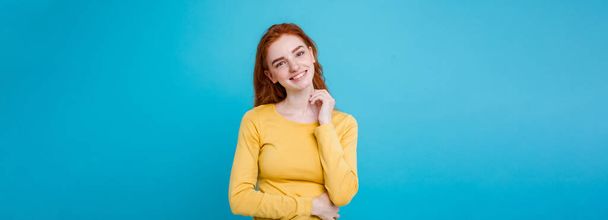 Ritratto di ragazza capelli rossi zenzero felice con lentiggini sorridente guardando la macchina fotografica. Sfondo blu pastello. Copia spazio
. - Foto, immagini