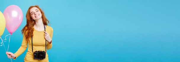 Estilo de vida y concepto de fiesta - Primer plano Retrato joven hermosa atractiva pelirroja chica de pelo rojo con globo de colores y cámara vintage. Fondo Pastel Azul. Copiar espacio
 - Foto, Imagen