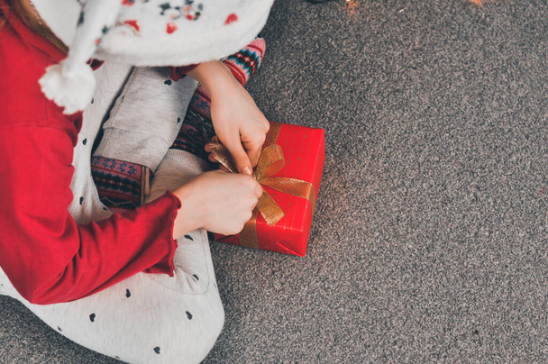 贈り物だ。子供たちはプレゼントを包む。赤いパッケージのクリスマスツリーの下の贈り物。クリスマスの新年. - 写真・画像
