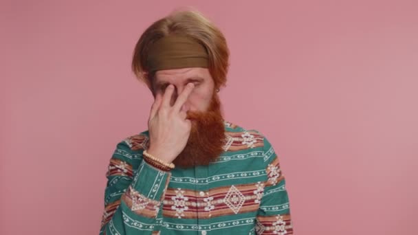 I am watching you. Hipster man in pattern shirt pointing at his eyes and camera, show I am watching you gesture, spying on someone. Young redhead hippie guy boy isolated on pink studio wall background - Footage, Video
