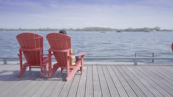 man sitting in the chair on the beach - Materiał filmowy, wideo