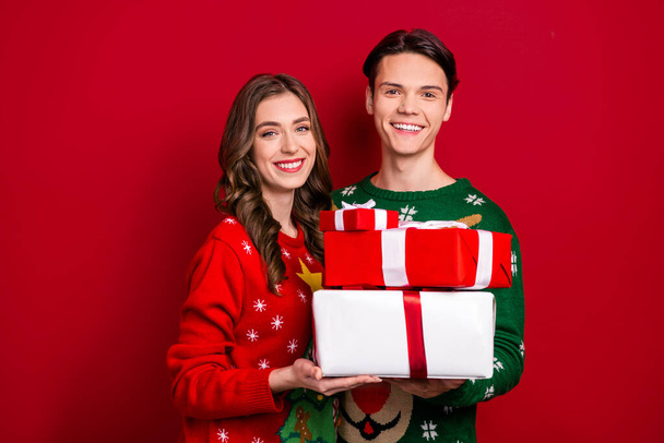 Portrait of two excited positive people hold pile stack festive giftbox isolated on red color background. - Foto, afbeelding