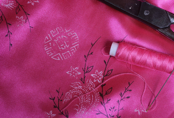 Spool of Pink Thread and Thimble on Vintage Pink Satin - Zdjęcie, obraz
