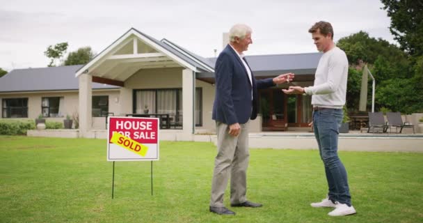 Men, mortgage and house, real estate and handshake with realtor for new property, homeowner and success on lawn. People shaking hands, buy and sold sign with successful sale on new house - Footage, Video