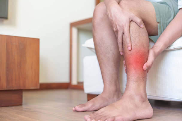 Mężczyzna ma ból nóg z powodu skurczu mięśni łydek i Shin Splints ból. urazy, zdrowie i koncepcja medyczna - Zdjęcie, obraz
