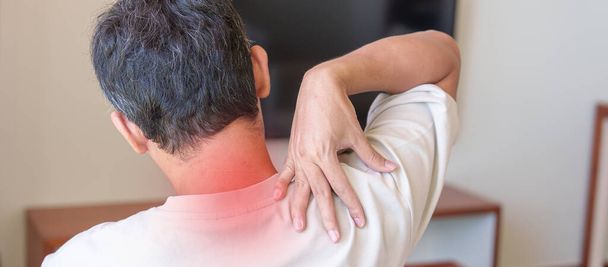 muž s bolestí krku a ramene při sezení na pohovce. v důsledku fibromyalgie, revmatismu, skulárních bolestí, kancelářského syndromu a ergonomické koncepce - Fotografie, Obrázek