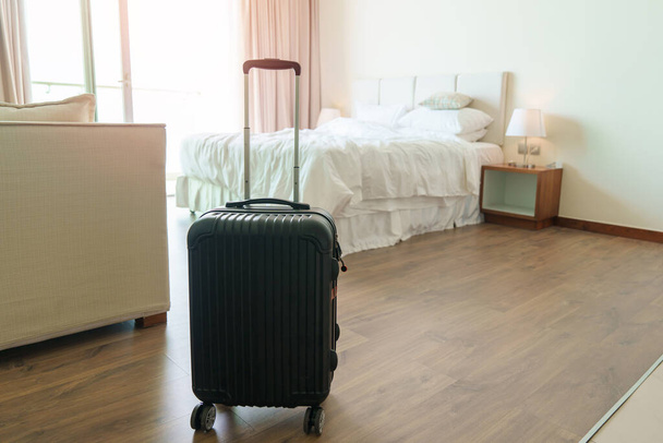 Μαύρες αποσκευές σε μοντέρνο δωμάτιο ξενοδοχείου μετά το άνοιγμα της πόρτας. Αποσκευές για το χρόνο ταξιδιού, υπηρεσίας, ταξιδιού, ταξιδιού, καλοκαιρινών διακοπών και διακοπών - Φωτογραφία, εικόνα