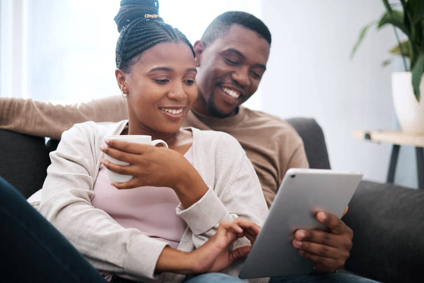 Digital tablet, relax and black couple on a sofa scrolling on social media, mobile app or the internet. Happy, smile and African man and woman reading messages together on a device in the living room. - Photo, Image