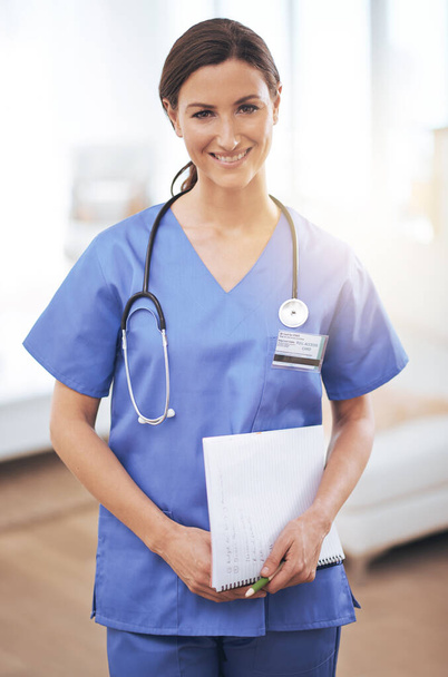 Zapewnia pacjentom najlepszą opiekę. Portret uśmiechniętej pielęgniarki trzymającej kartę medyczną - Zdjęcie, obraz