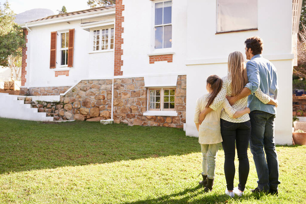 Not just a house, but a home. A family standing outdoors admiring their new home - Photo, Image