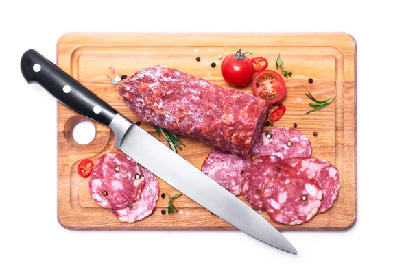 Sliced Smoked dry Salami sausage on wooden cutting board isolated on white background. - Fotoğraf, Görsel