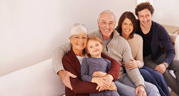 Familie ist alles. Zugeschnittenes Porträt einer glücklichen Mehrgenerationenfamilie, die zusammen auf einem Sofa sitzt - Foto, Bild