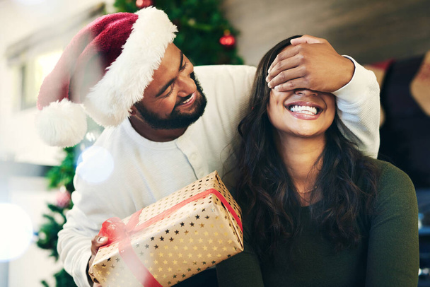 Para, Boże Narodzenie i święto z niespodzianką i prezentem, szczęśliwy na wakacjach z pudełkiem i świąteczną tradycją. Świętuj, kochaj i uśmiechaj się, zakryj oczy obecną tajemnicą z mężczyzną i kobietą z Meksyku - Zdjęcie, obraz