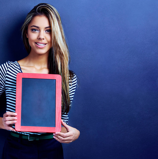 Get your message out there. an attractive young woman holding a chalkboard - Фото, зображення