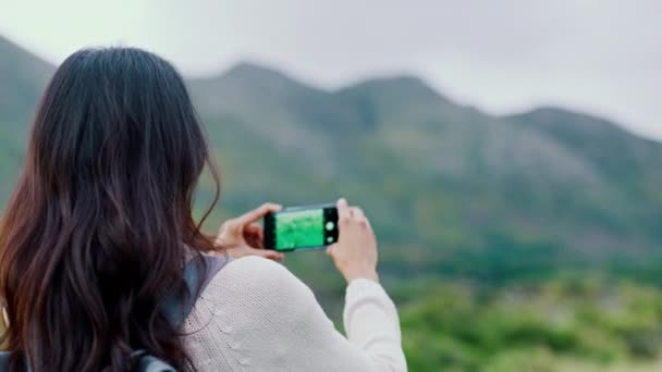 Fényképezés, természet és a hegy egy nő használja a telefonját, miközben városnézés során utazás vagy nyaralás. Szabadság, hegyek és okostelefon egy női utazó fényképez a vadonban. - Felvétel, videó
