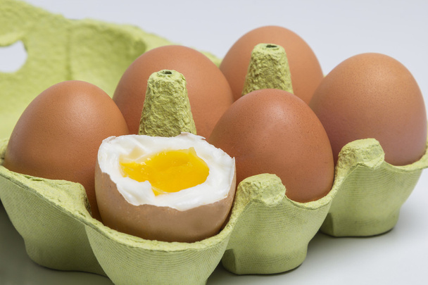 Scatola di uova con un uovo sodo rotto
 - Foto, immagini