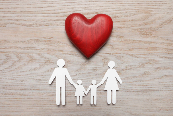 Paper family cutout and red heart on white wooden background, flat lay. Insurance concept - Foto, imagen