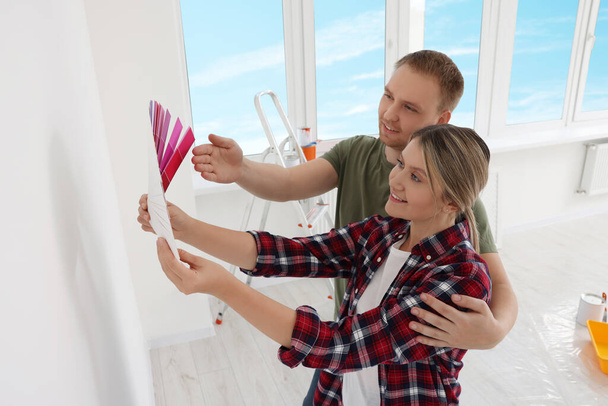 Couple with paint chips discussing new wall color in apartment during repair, above view. Space for text - Fotoğraf, Görsel