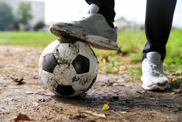 Man with dirty soccer ball outdoors, closeup - Fotoğraf, Görsel