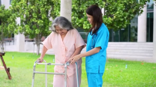 Азиатский заботливый ухаживающий или медсестра заботится о пожилом азиатском пациенте в инвалидном кресле. Концепция счастливого выхода на пенсию с заботой от сиделки и сбережений и старшего медицинского страхования. уход за пожилыми - Кадры, видео