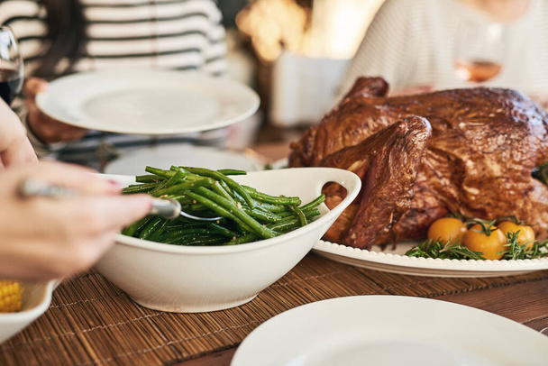 家族、友人、愛する人の世話をしてテーブルで昼食を提供する食べ物、感謝祭、手。一緒にお祝い、七面鳥と伝統的なお祝いの休日の食事、感謝と感謝 - 写真・画像