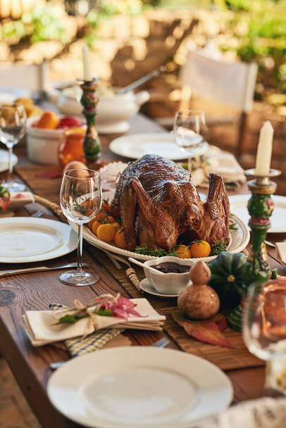Thanksgiving, eten en kalkoen tafel voor dankbaarheid, bedankt en gratie vakantie lunch buiten. Rooster, vakantie en feestelijke outdoor diner maaltijd met kleurrijke decoratie voor USA viering - Foto, afbeelding