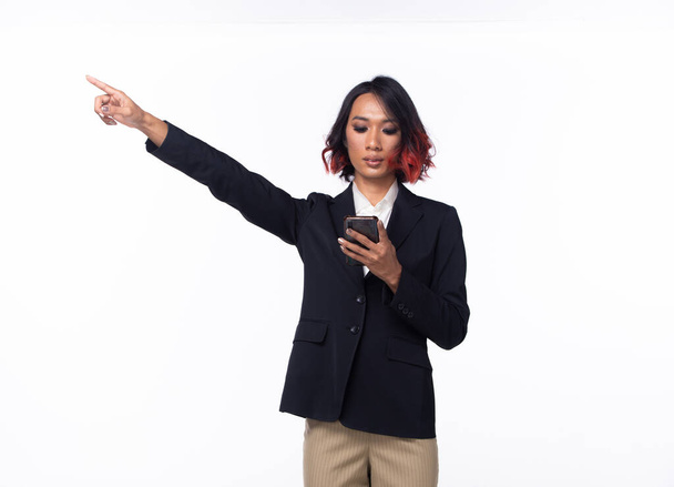 Half body Tanned skin Asian Indian woman points finger hand up to Sky, Business Blazer female has confident smart hold smart phone to future empty area air, studio white background isolated - Photo, Image