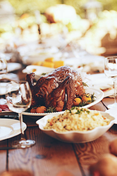 感謝祭の休日の食事のための七面鳥、鶏や鶏と感謝祭、テーブルと食べ物背景がぼやけている。ごちそう、ディナーやランチで健康的な鶏との素晴らしい食事、お祝いや裏庭のパーティー. - 写真・画像
