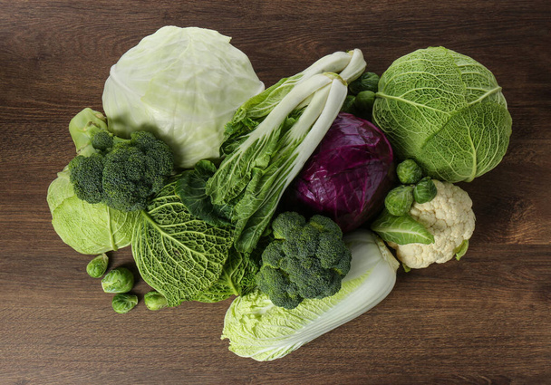 Many different fresh ripe cabbages on wooden table, top view - Fotoğraf, Görsel