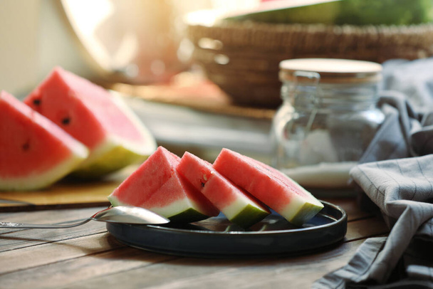 Sliced fresh juicy watermelon and spoon on wooden table - Φωτογραφία, εικόνα
