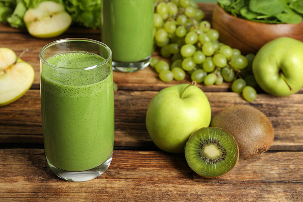Green smoothie and fresh ingredients on wooden table - Φωτογραφία, εικόνα