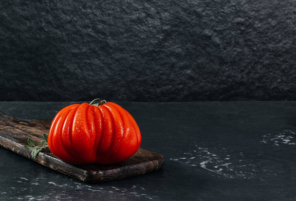 Three fresh Raf Coeur De Boeuf tomato, dark background, rustic concept, space for text, stock photo - Photo, Image