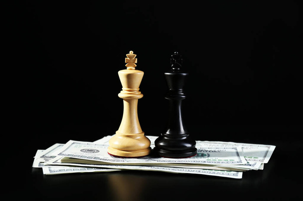 Money, white and black kings against dark background. Business competition concept - Foto, immagini