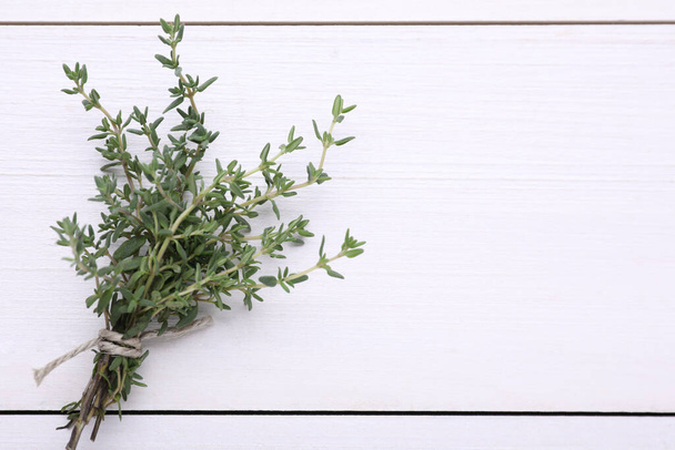 Bunch of fresh thyme on white wooden table, top view. Space for text - Foto, imagen