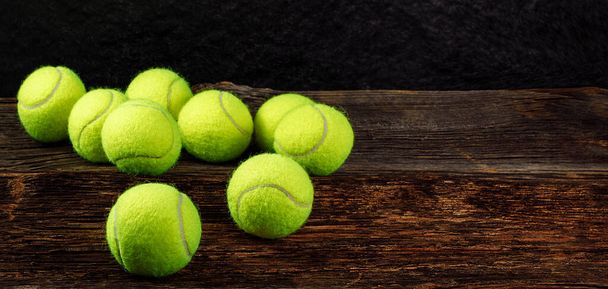Bolas de tenis amarillas sobre fondo de madera, espacio para texto, deporte y concepto de competición - Foto, Imagen