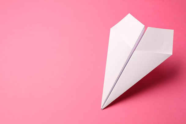 Handmade white paper plane on pink background, space for text - Foto, imagen