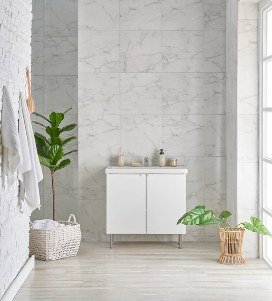 Łazienka w stylu wnętrz z lustrem i białym ceramicznym tłem, materiał czyszczący, ręcznik, wiklinowy wazon roślin, wystrój wnętrz. - Zdjęcie, obraz