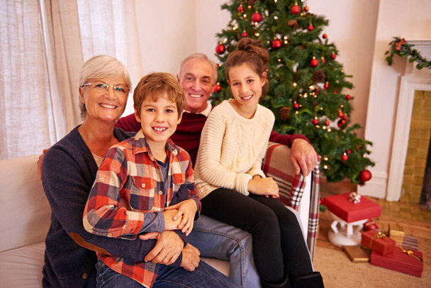 Christmas, senior couple and couch for grandchildren, happiness or relax for festive season in lounge. Xmas, love or portrait for elderly man, mature woman or grandkids or happy with smile or content. - Foto, immagini