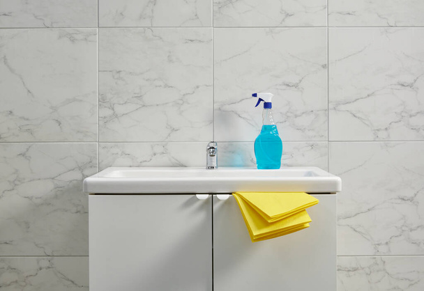 Kits de nettoyage sur l'évier de l'armoire dans la salle de bain, tissu jaune, gros plan. - Photo, image