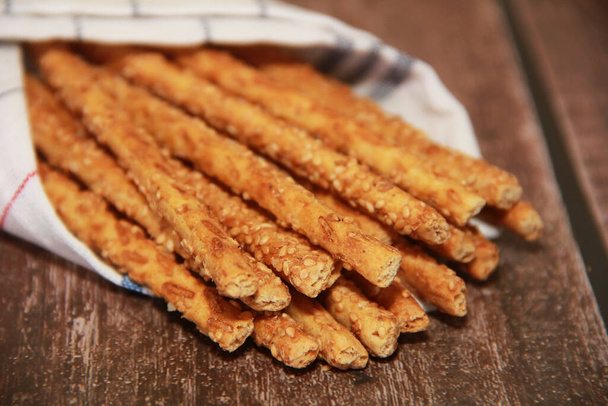 bâtonnets de pain de sésame sec avec de petites graines pour la nutrition diététique, sur un fond en bois - Photo, image