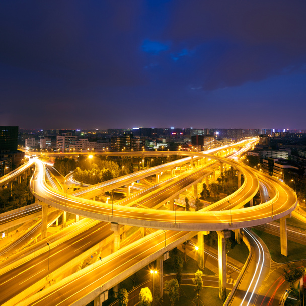 Skyline and traffic trails on highway intersection - Photo, Image