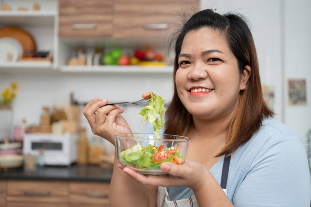 Asyalı Hamile, mutfakta internetten sağlıklı yemek yapmayı öğreniyor, şişman kadınlar diyet yemeği için sebze salatası hazırlıyor ve kilo veriyor. Sağlıklı beslenme kavramı - Fotoğraf, Görsel