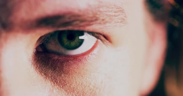 Dark, horror and scary eyes on a man with vision, focus and danger on a dark background. Zoom, studio and closeup portrait of the pupil of a person with spooky eyesight, scared and face of young guy. - Metraje, vídeo