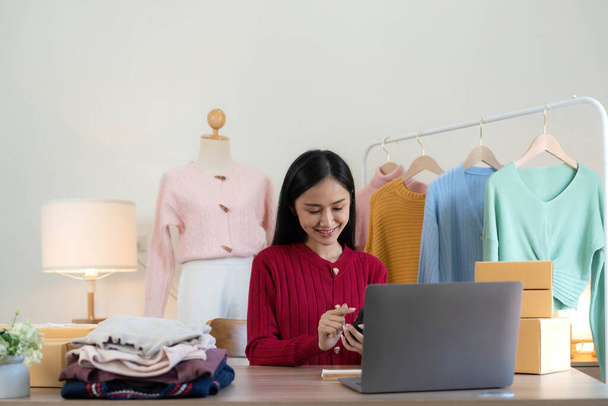 Küçük işletmeler kurma portresi KOBİ sahipleri ve Asyalı kadın çevrimiçi siparişleri kontrol ediyorlar. Ev işlerinde çalışan kutucuklarla çalışan ürünler satıyorlar. Çevrimiçi küçük işletmeler kuruyorlar... - Fotoğraf, Görsel