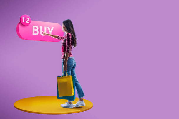Woman holding shopping bags and pressing a buy button, online shopping and virtual reality concept - Foto, Imagem