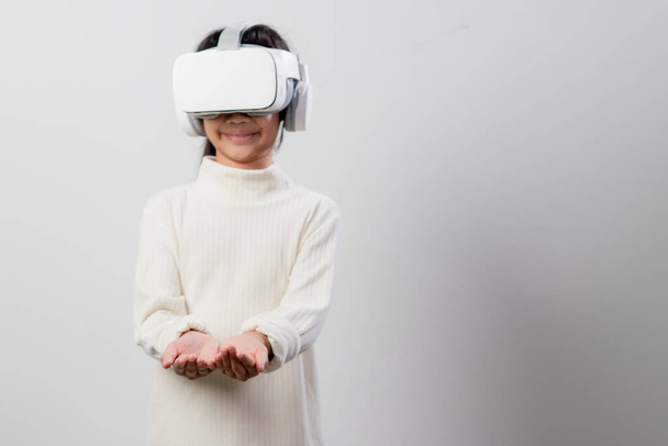 Азиатская маленькая девочка с гарнитурой виртуальной реальности. Инновационные технологии и концепция образования - Фото, изображение