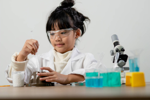 educazione, scienza, chimica e concetto di bambini - bambini o studenti con esperimento di creazione di provette presso il laboratorio scolastico
 - Foto, immagini